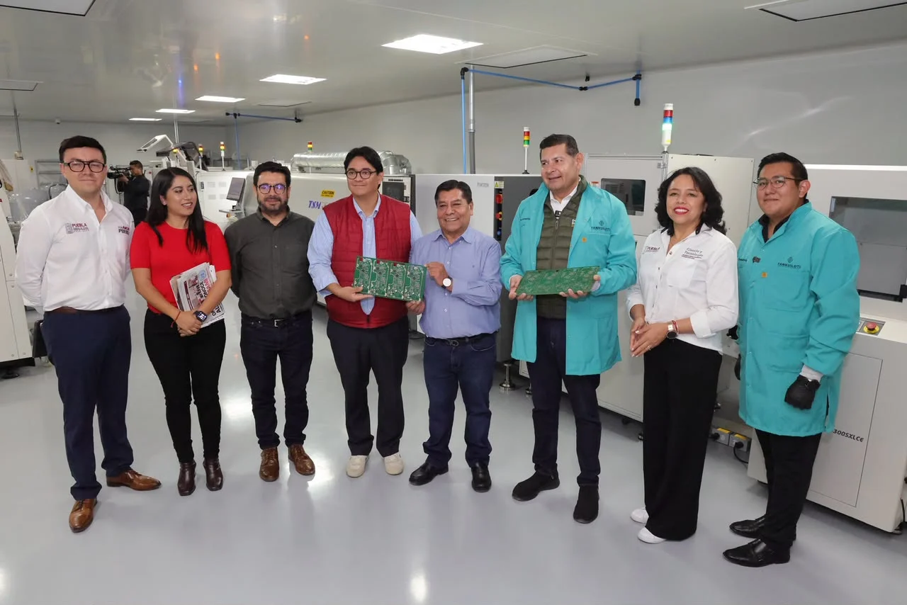 Gobernador Alejandro Armenta Mier posa junto a funcionarios y personal técnico dentro de la planta de Yankuilotl, sosteniendo tarjetas de circuito ensambladas.
