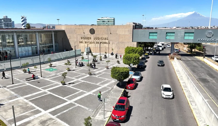 Vista aérea de la fachada del edificio del Poder Judicial del Estado de Puebla, con explanada, vialidad y el volcán Popocatépetl al fondo.