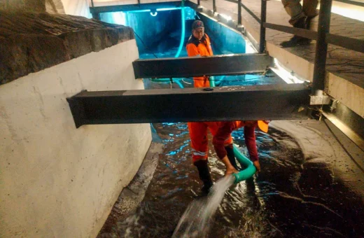 Personal de Limpia con uniforme naranja lava el Puente de Bubas con manguera tras la lluvia en Puebla.
